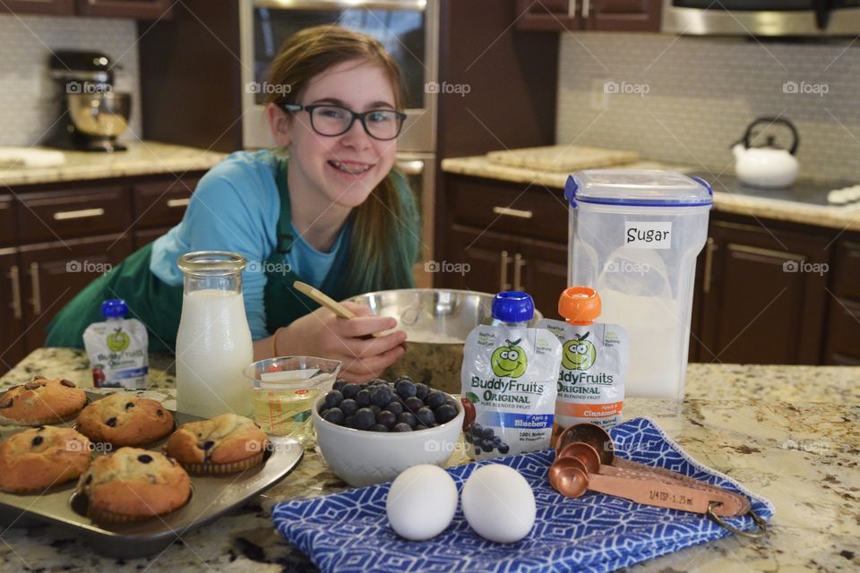 Girl baking muffins with a secret ingredient of buddy Fruits in the batter to keep it moist 