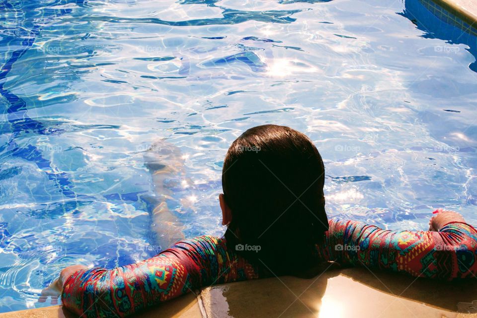 Child enjoying summer in swimming pool