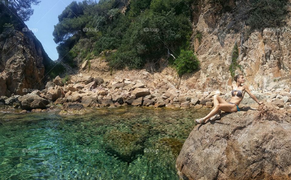 Woman in bikini on rock