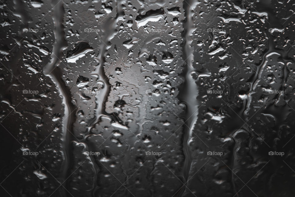 Droplets on a bus window glass, it was hard rain in a city and I love the texture and shape the droplets made