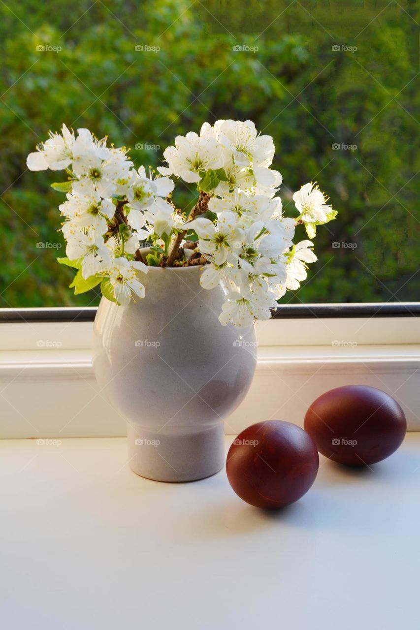 spring holiday flowers in vase and red Easter eggs