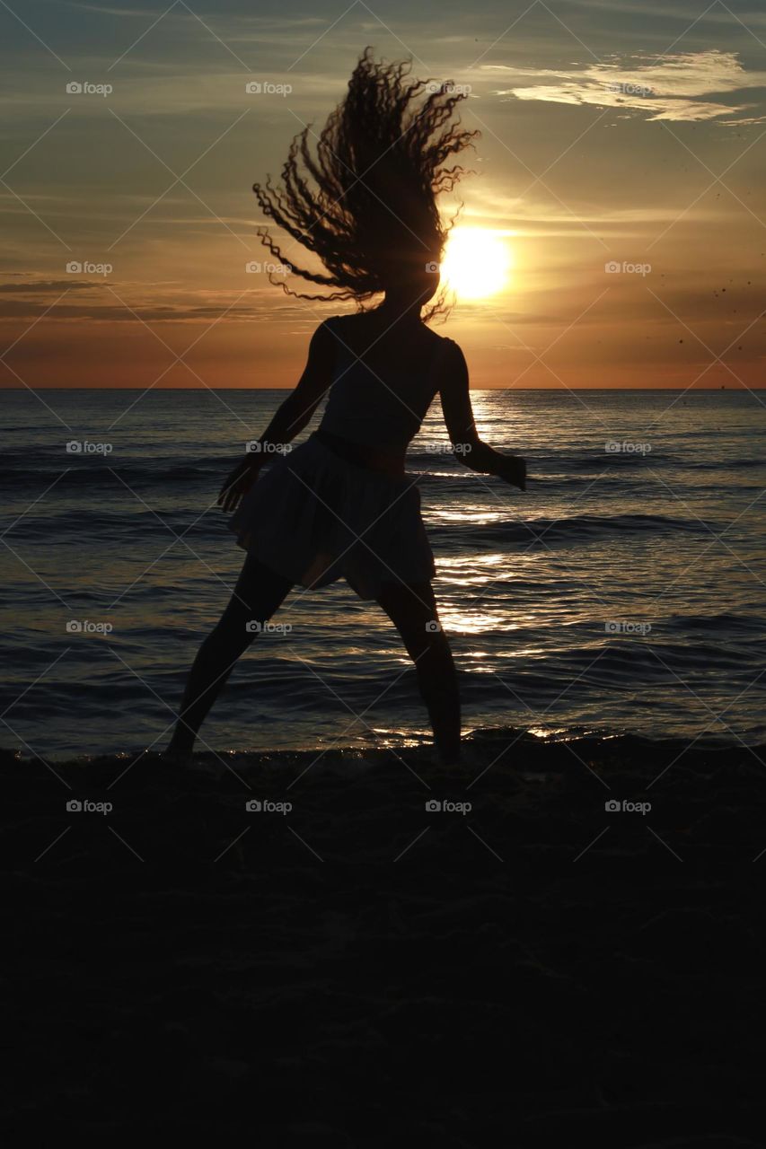 Dancing girl in the sunset rays.