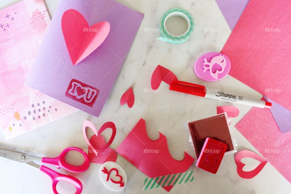 Homemade Valentine's Day greeting cards with stamps and heart cutouts.