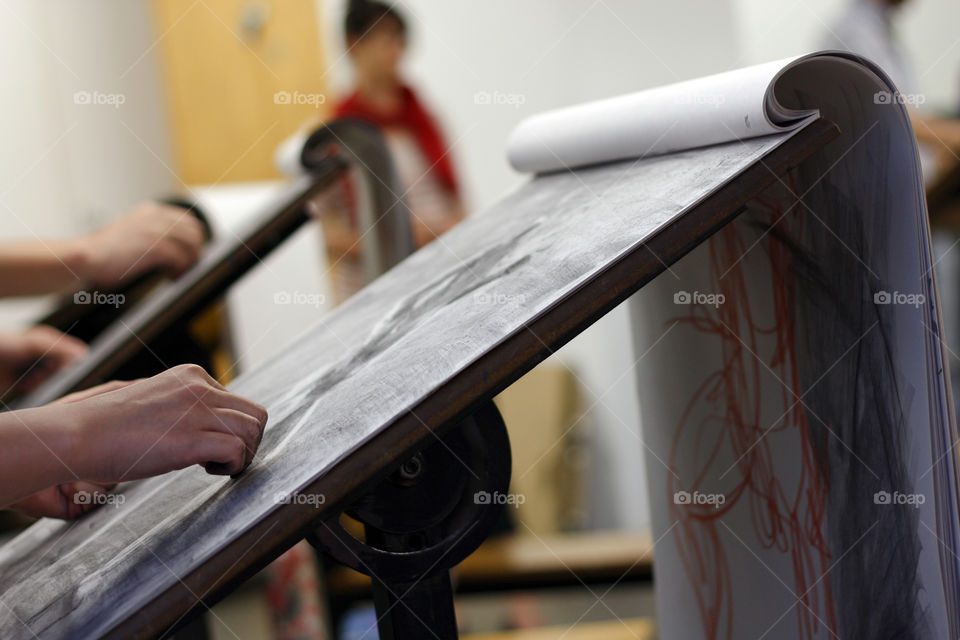 An artist sketches a model in the studio