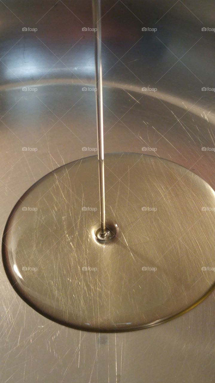 oil falling into large circle of oil