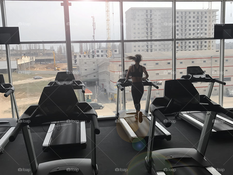 Young woman running at the track in the gym