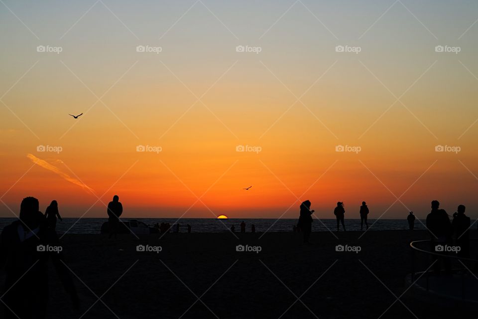 Tourist enjoying at beach during sunset