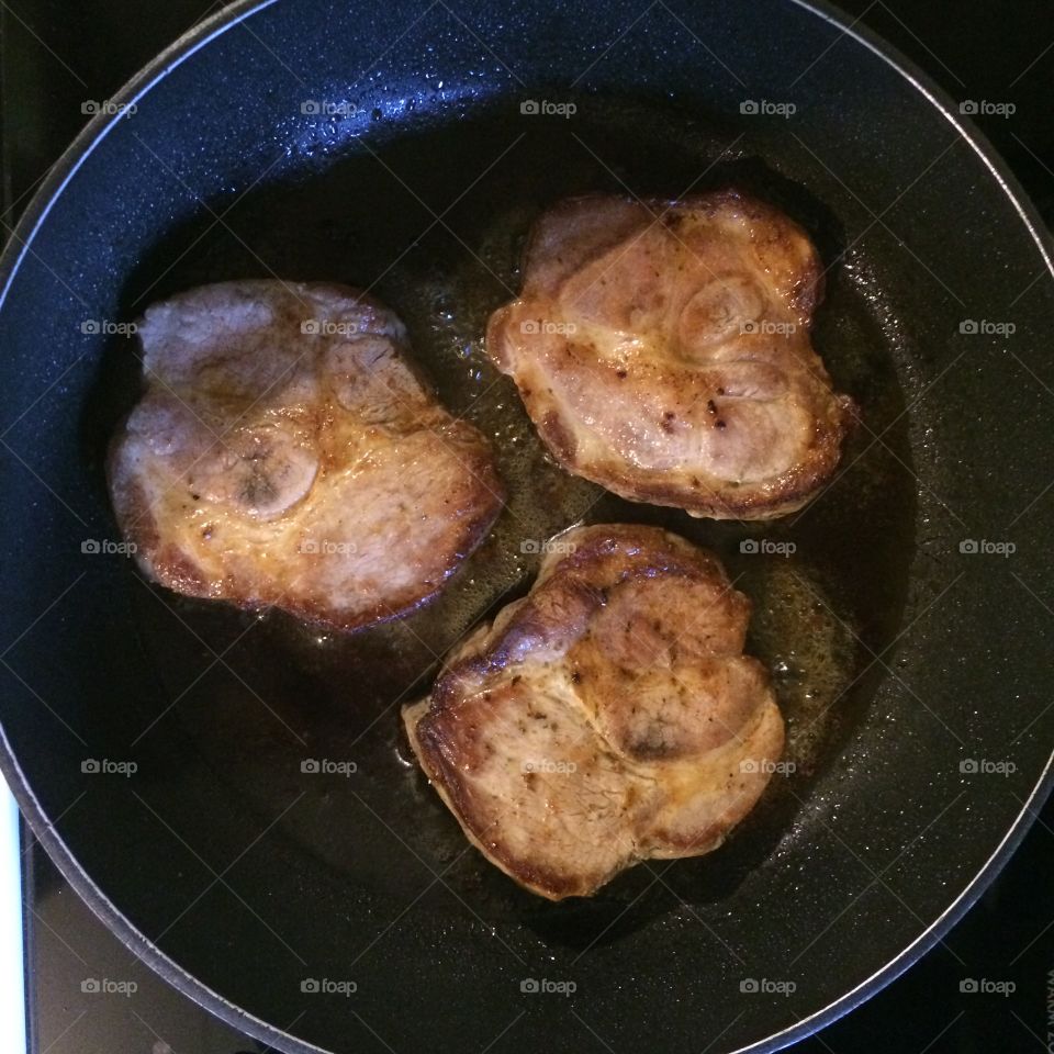 Pork chops with garlic butter in the frying pan