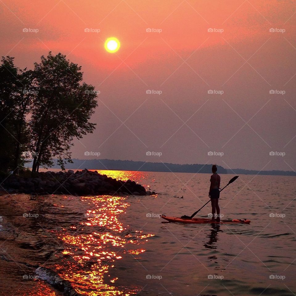 Sunset on lake paddle boarding  