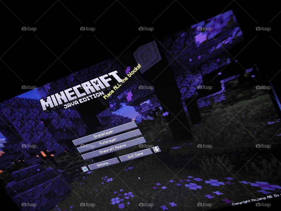 Video game photography taken of the game Minecraft from a gaming computer screen in a dark room at the start of the game showing the menu from the start.