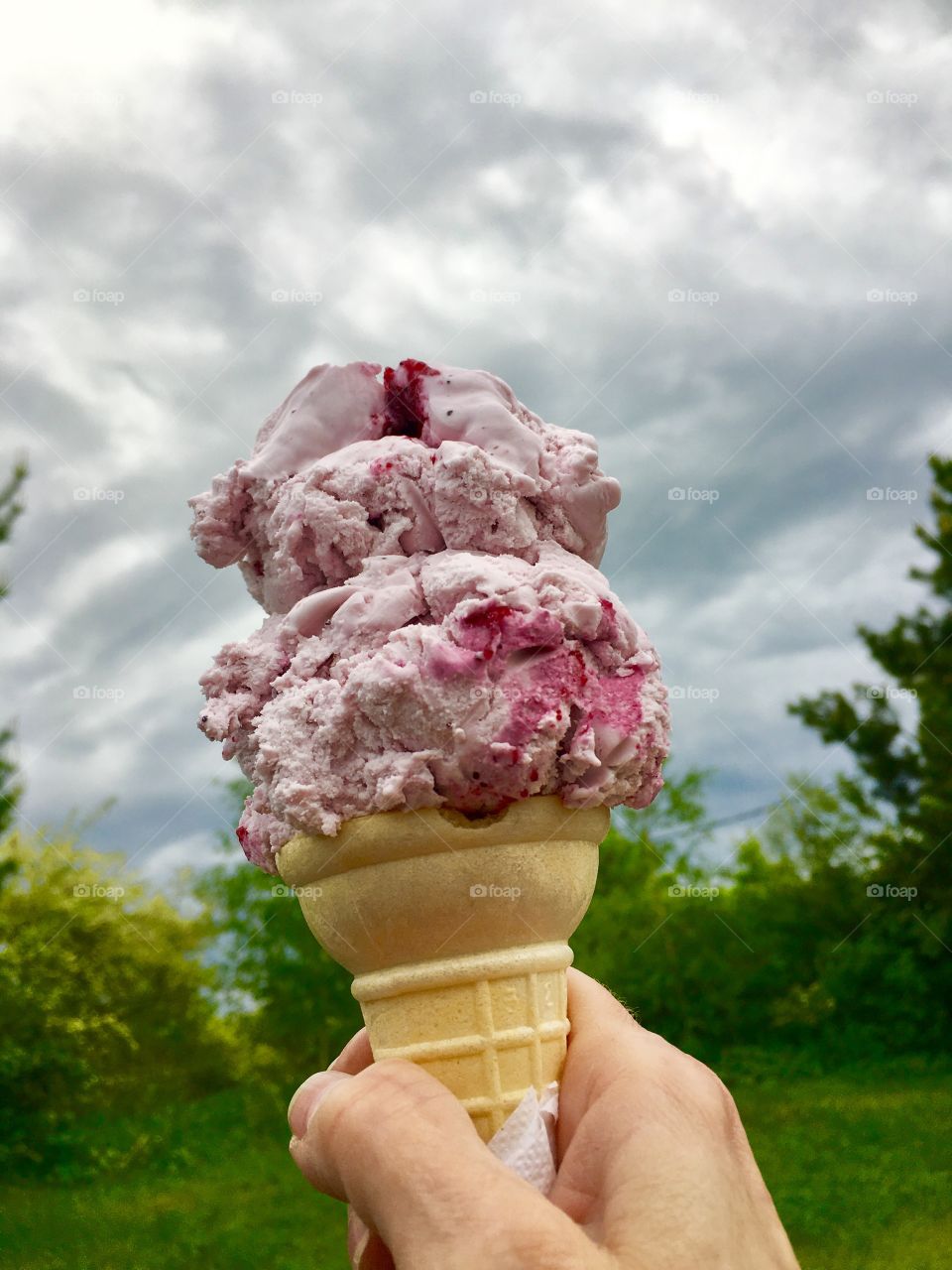 Ice cream cone in hand outdoors