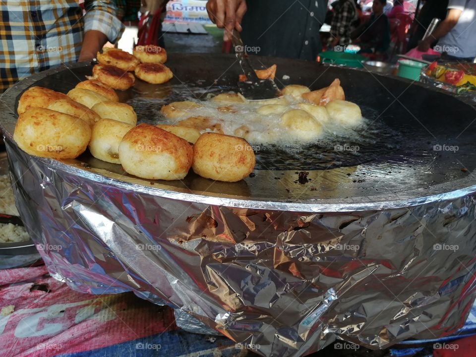 Frying Aloo or potato with hot oil in street stall and fried these potato and lead to making of Aloo  tikki or potato tikki.