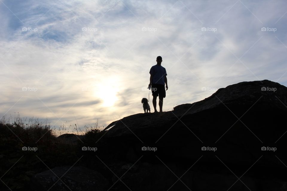 Man and his buddy walking during sunset