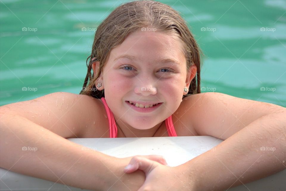 Smiling girl enjoying in pool