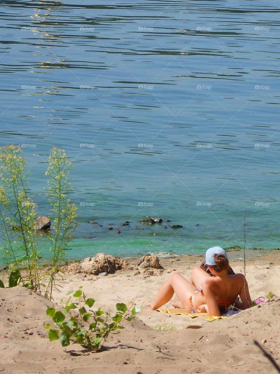 girl sunbathing on the beach on the Dnieper river in the city of Kiev, Ukraine