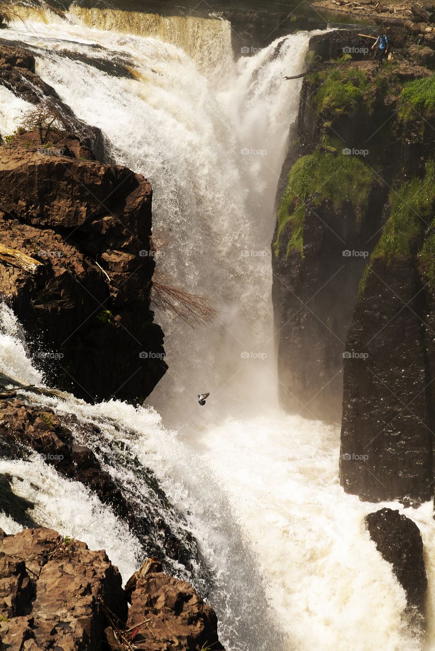 A hiker stands at the cliff of Paterson Great falls National historic park in New Jersey.