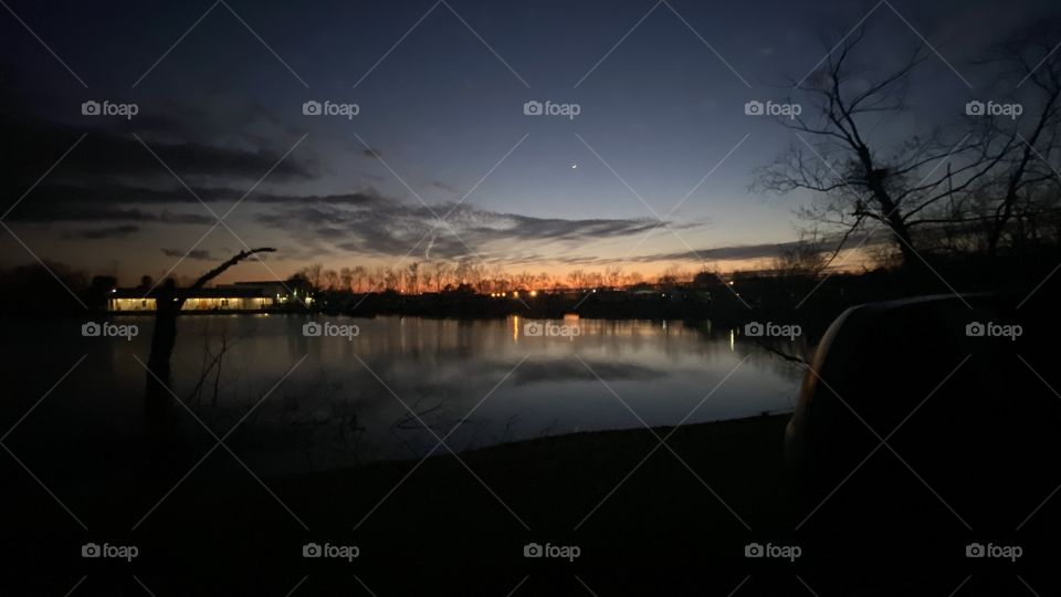 Green Sky at night keeps Sailors Wishing for Better Nights. Long Exposure Photo with Picture Prefect Clear Night Reflections of Land Shore Trees. Lake Waters Calm. Horizon Colors from Backlit Night. Beautiful.