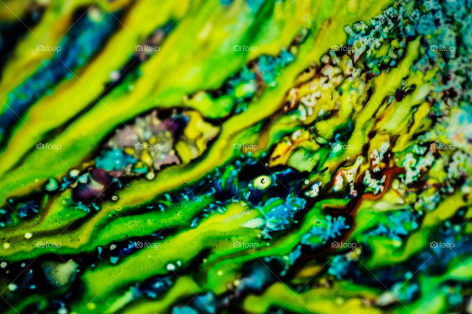 The ink to refill the printer cartridge was spilled onto the white washbasin and the paints blended into abstract drips and patterns.