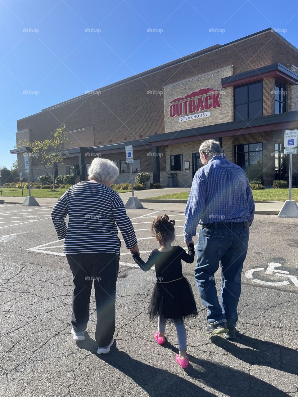 Little girl is taking grandparents to steak house, delicious steak dinners, birthday treats for grandparents, eating at Outback Steakhouse 