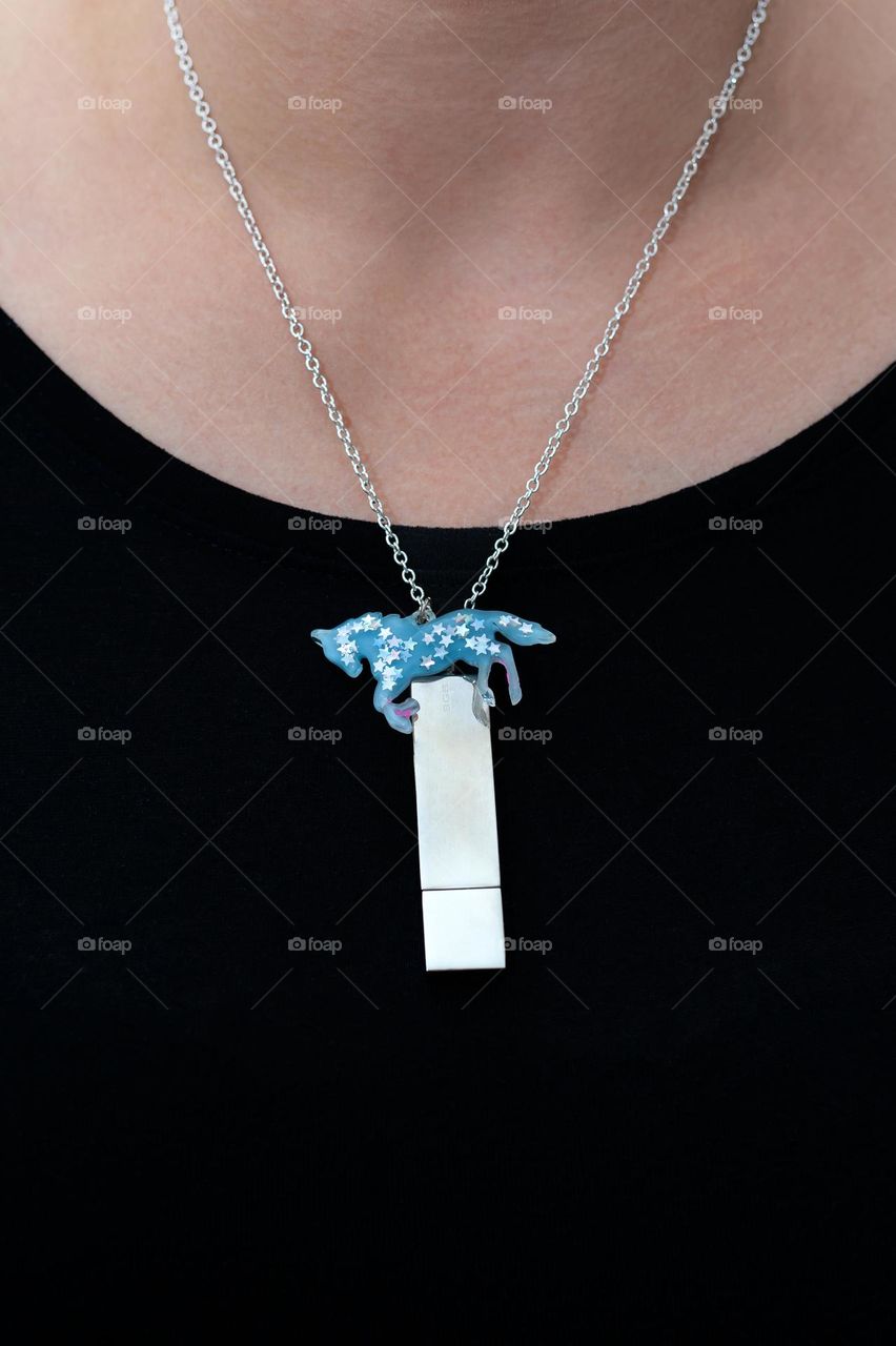 Pen drive as a jewellery on woman neck with little blue  unicorn.