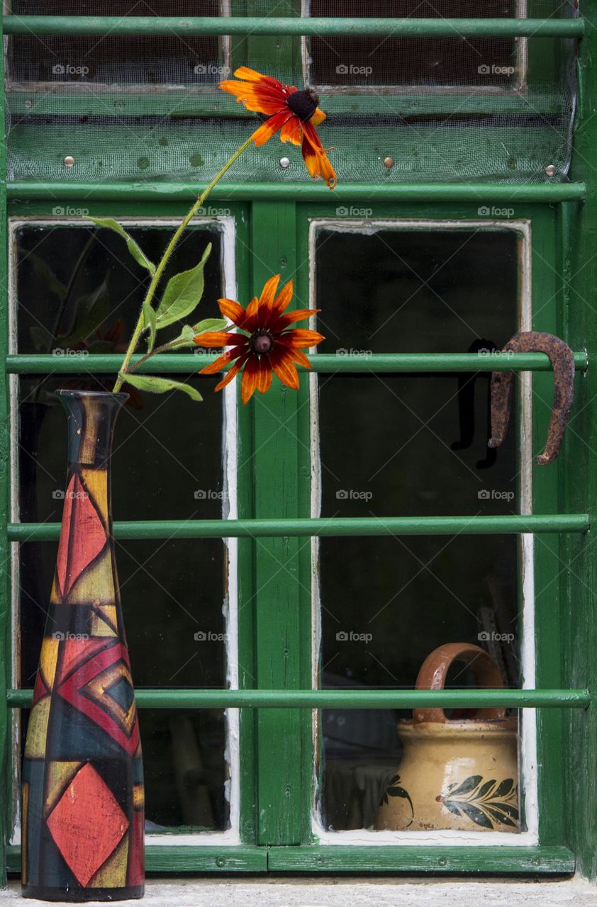 Flower in a vase on the window of country house