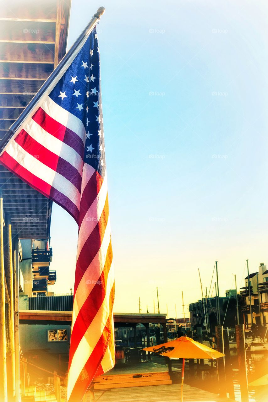 The flag of the United States of America flying outside a store.