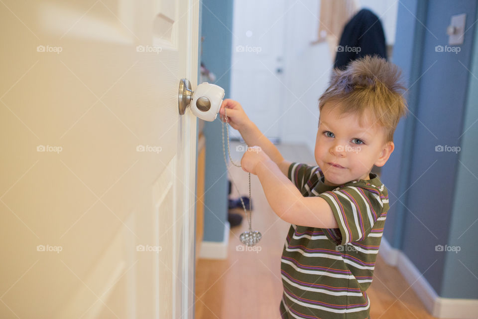 Toddler Playing with child proof door lock 