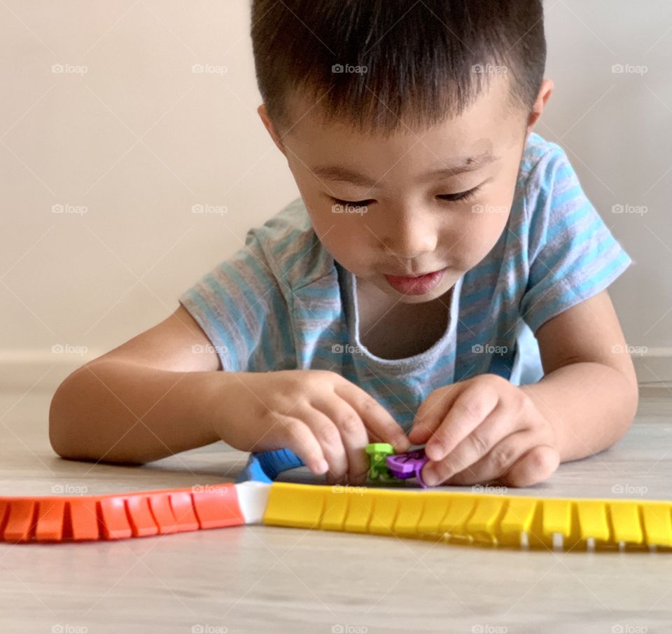 Asian boy playing with colourful toys 