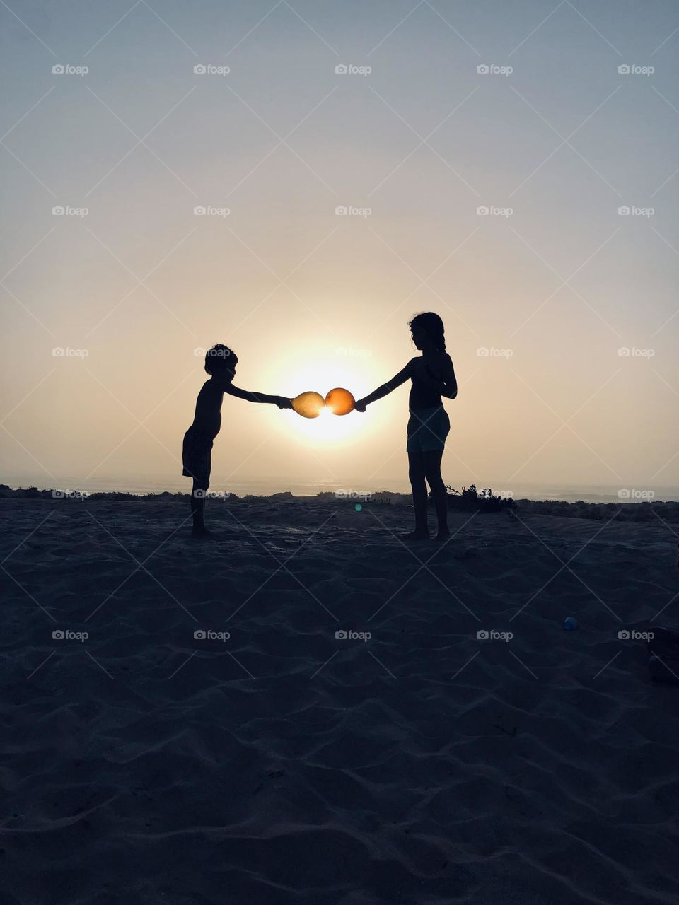 Beautiful children holding the balloons against golden sun at essaouira city in morocco 