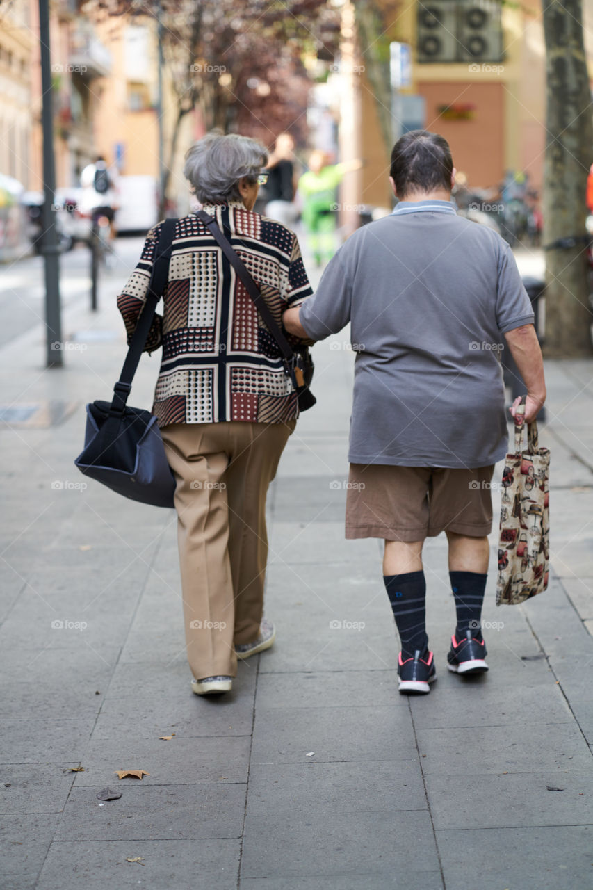 Elderly woman with a handicapped man walking together 