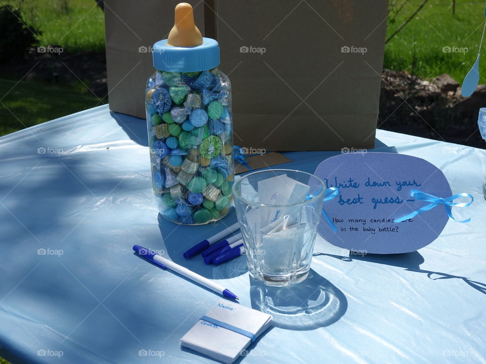 A baby bottle full of candies provides an entertaining guessing game at a baby shower. 