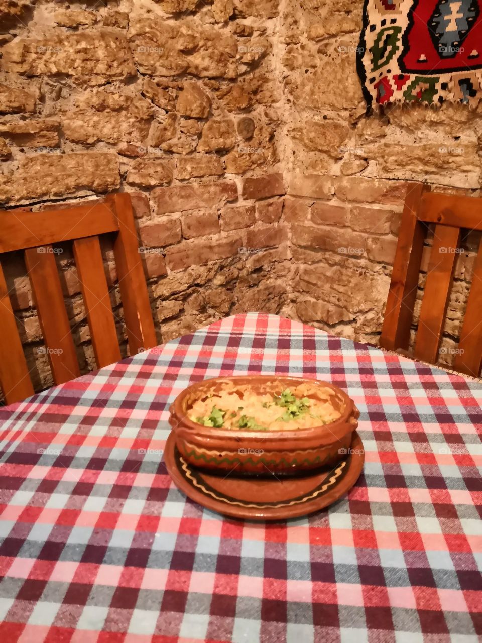 Traditional Macedonian food in a traditional interior. The name of the food: Tavche Gravche.