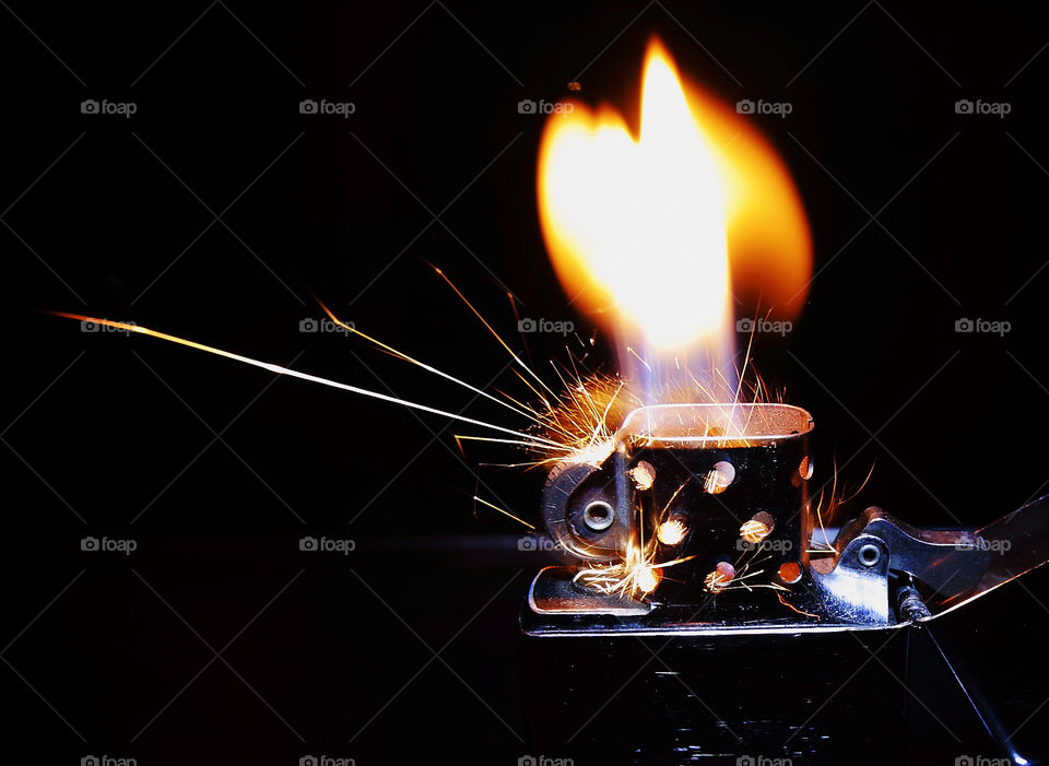 Ignited cigarette lighter against black background