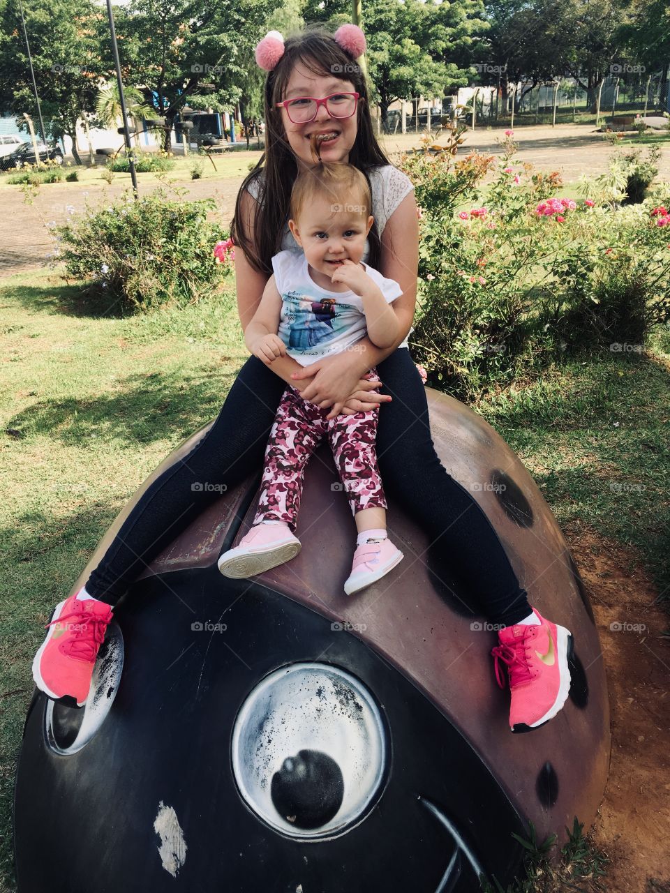 As duas irmãs (e princesas) se divertindo sentadas na joaninha gigante. É bom demais brincar, não?