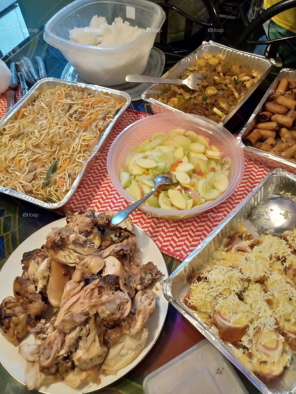 TRADITIONAL FOODS LIKE BAM-I, SLICED FRIED CHICKEN, COOKED WHITE RICE, SLICED RAW FRUITS, FRIED PORK LUMPIA, TANGHON ETC.