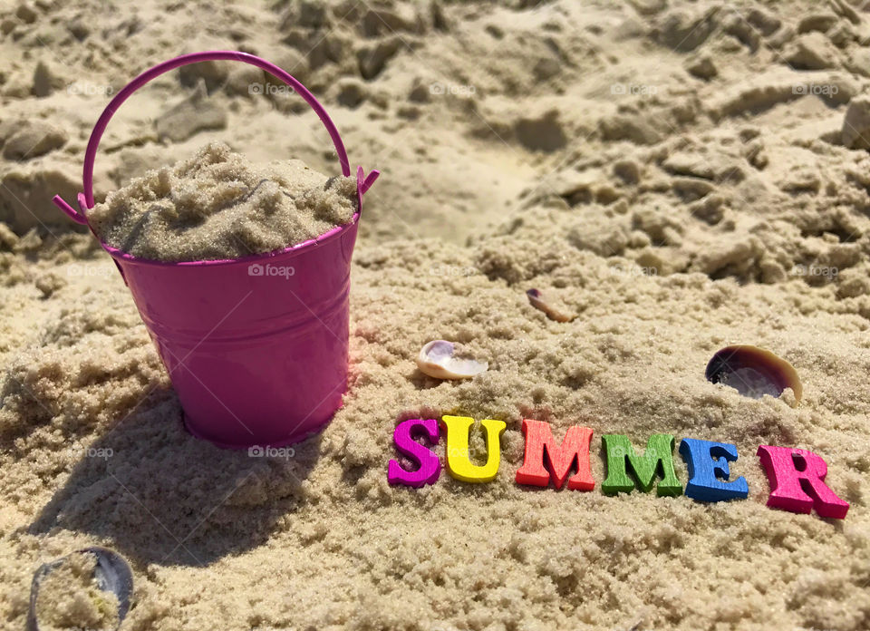 Sand and wooden letters, word summer 