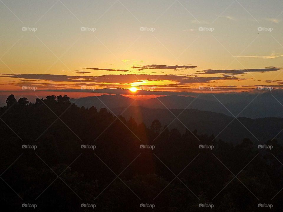 it's time for golden hour, soft and golden coloured rays spreading from horizon, cloudy sky, perfectly captured at dawn, hills and mountains view, sunset view