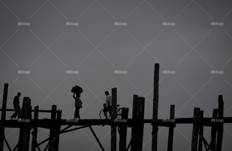 Myanmar local life style ,People carry goods on her head are walking to morning market on U being bridge , the most longest wooden bridge in the world