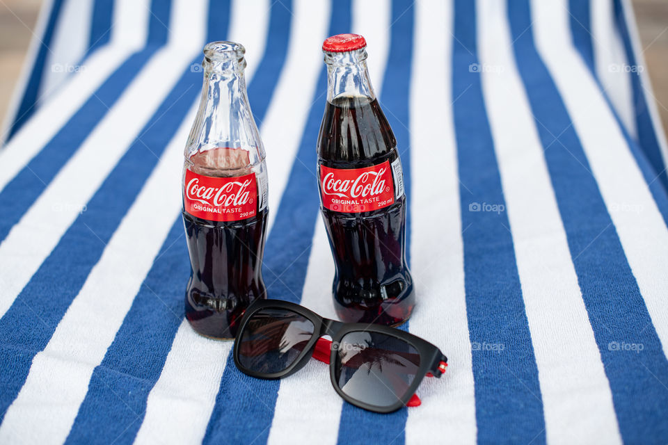 Two bottles of Coca-Cola and sun glasses