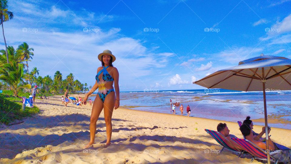 She at Praia do forte , with a beautiful postcard as a background