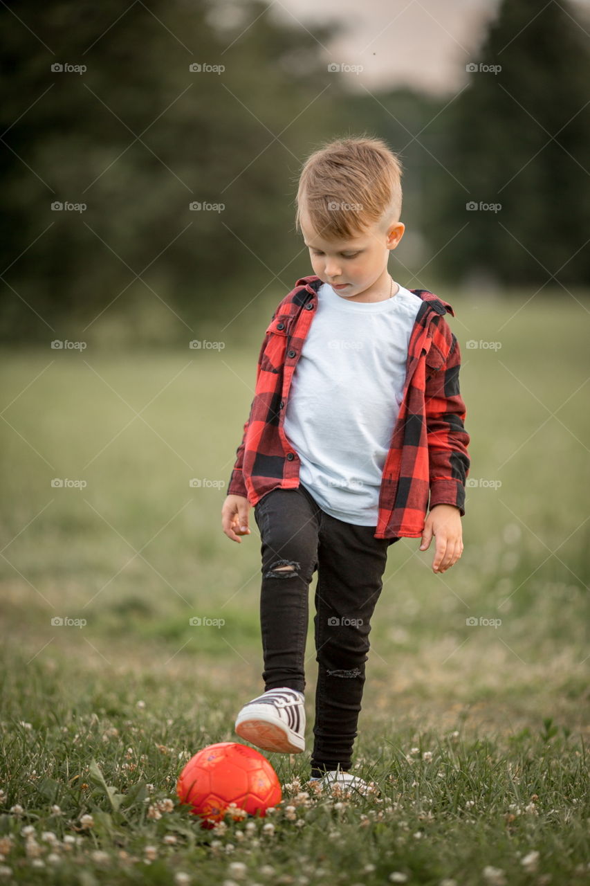 Little boy playing in soccer in a park 