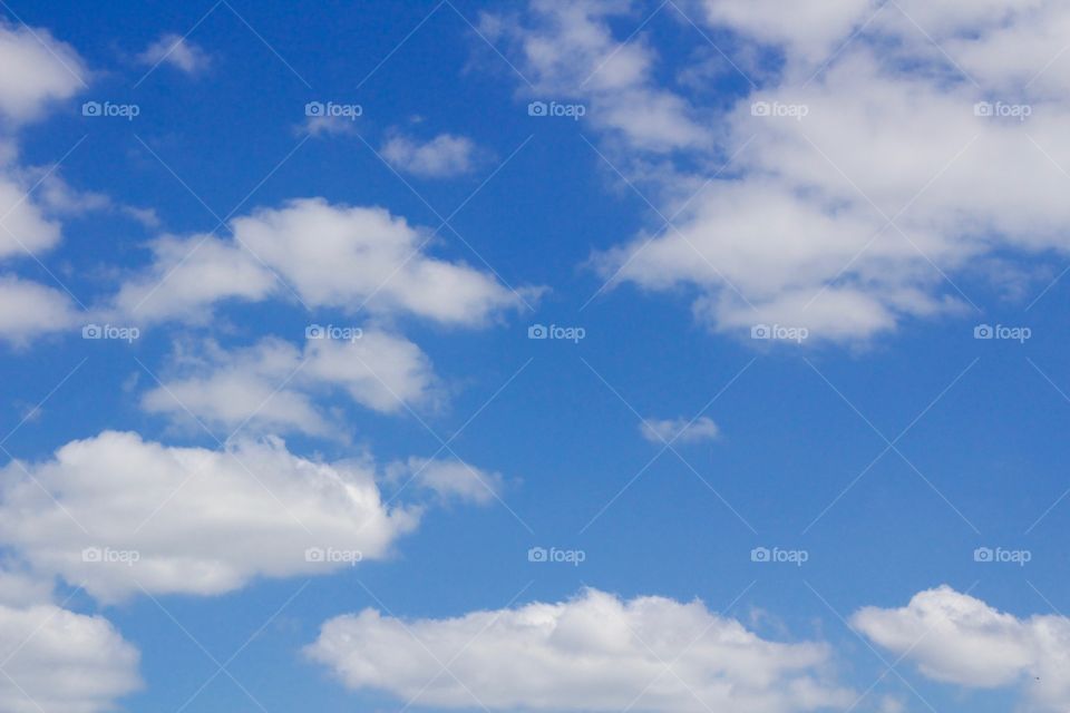 Puffy white clouds against a vivid blue sky