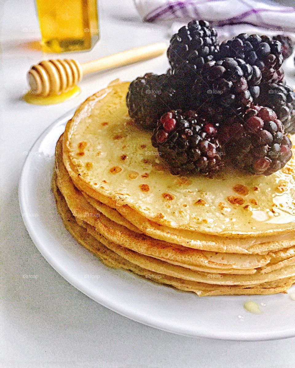 Stack of tortilla with blueberries in plate