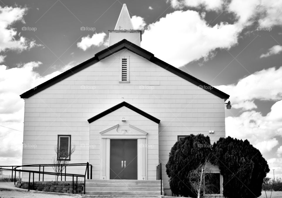 A Church that has now closed its doors due to lack of funding with clouds in the background 