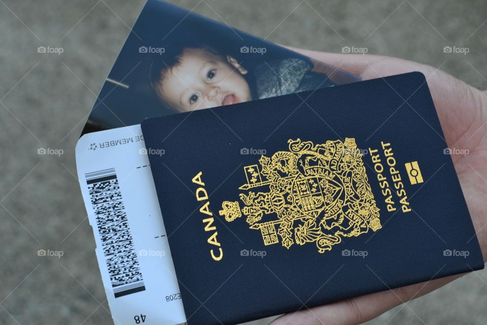 Single dad father parent reaching into back pocket for passport and boarding pass also includes photo of his son 