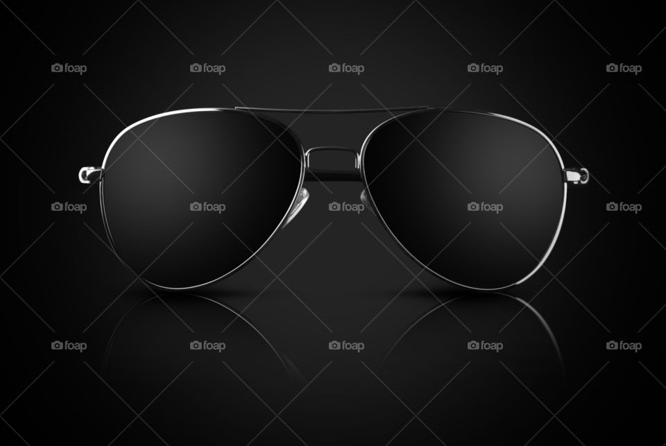 Black aviator sunglasses with reflection on black background