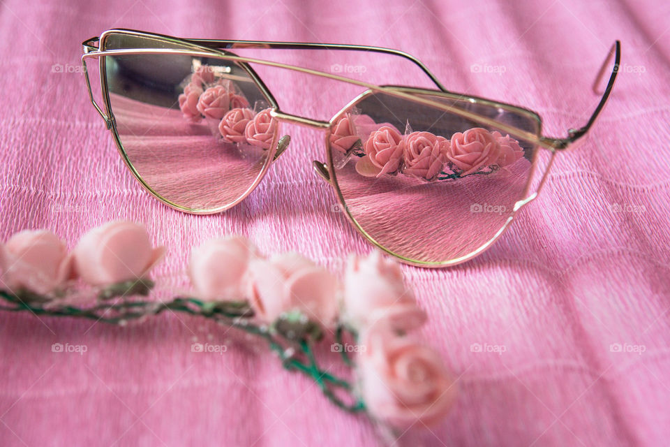 Sunglasses with flowers on pink surface