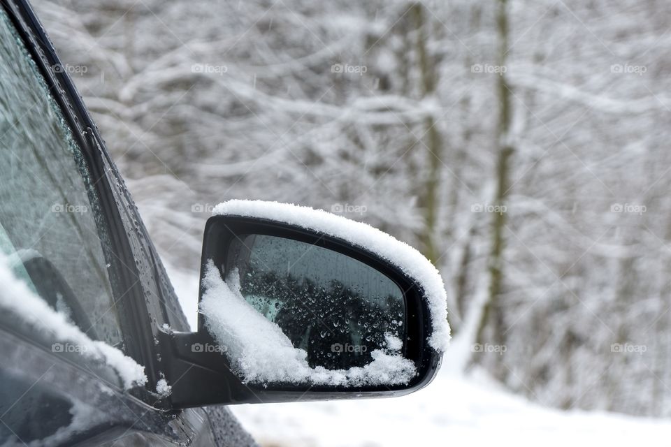 Rear car mirror with snow during winter. Slovakia