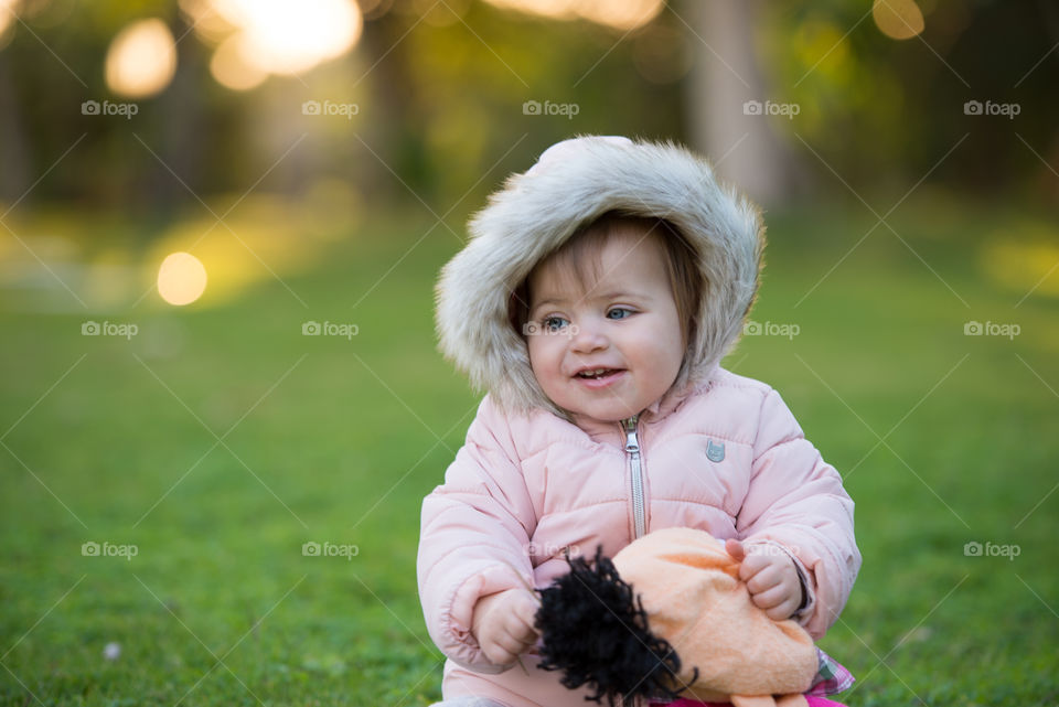 baby girl smiling wearing pink coat