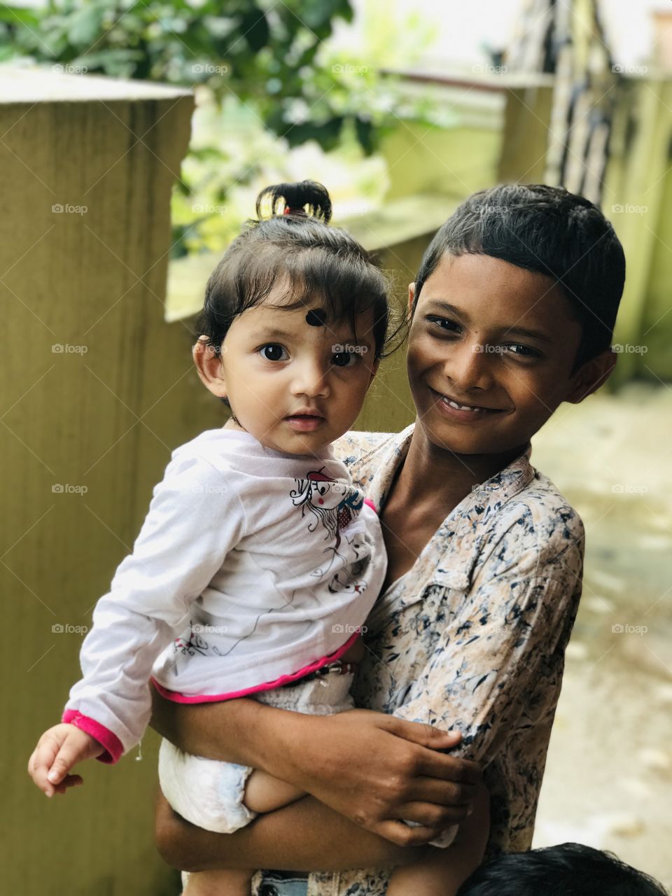 Indian boy holds his little cute sister 